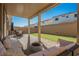 View of the backyard with covered patio, artificial grass and privacy wall at 10415 Andele Ave, Las Vegas, NV 89166