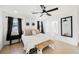 Bedroom featuring a king-size bed, ceiling fan, two windows with black curtains, and stylish accents at 10415 Andele Ave, Las Vegas, NV 89166