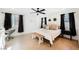Bright bedroom with a ceiling fan, two windows with black curtains, and a cozy king size bed at 10415 Andele Ave, Las Vegas, NV 89166