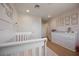 Bedroom features a white crib, bright paint and wood-look flooring at 10415 Andele Ave, Las Vegas, NV 89166