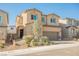 View of a two-story tan home with desert landscaping and a brick driveway at 10415 Andele Ave, Las Vegas, NV 89166