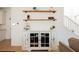 Cozy living room featuring a rustic cabinet with decorative shelves and light wood-look flooring at 10415 Andele Ave, Las Vegas, NV 89166