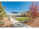 Community playground featuring a covered play structure, turf, and walking path under a clear blue sky at 10415 Andele Ave, Las Vegas, NV 89166