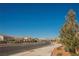 Well-maintained street in a residential area, featuring mountain views and lush trees, offering a scenic drive at 10415 Andele Ave, Las Vegas, NV 89166
