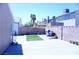 Spacious backyard showcasing a concrete patio, partial artificial turf, brick walls, and a grill at 115 Parrish Ln, Las Vegas, NV 89110