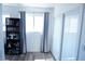 Bright bedroom featuring sliding glass doors, light-blocking curtains, and neutral walls and flooring at 115 Parrish Ln, Las Vegas, NV 89110