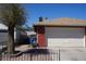 Attached two-car garage with brick accents, landscaping and a wrought iron fence at 115 Parrish Ln, Las Vegas, NV 89110