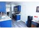 Efficient kitchen showcasing bright blue cabinetry, light gray flooring, and stainless steel appliances at 115 Parrish Ln, Las Vegas, NV 89110