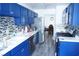 Well-lit kitchen boasting bright blue cabinetry, light countertops, and sleek stainless steel appliances at 115 Parrish Ln, Las Vegas, NV 89110