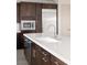 Modern kitchen featuring a white countertop island, stainless steel appliances, and dark wood cabinetry at 1172 Monte De Luz Way, Henderson, NV 89012