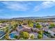 Aerial view of a community with lush landscaping, pools, and mountain views at 11730 Stonewall Springs Ave, Las Vegas, NV 89138