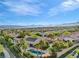 Aerial view of a community with lush landscaping, pools, and mountain views at 11730 Stonewall Springs Ave, Las Vegas, NV 89138