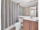 Well-lit bathroom with a shower, vanity, toilet and large mirror at 11730 Stonewall Springs Ave, Las Vegas, NV 89138