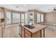 Bright and spacious kitchen featuring an island with a stainless sink, seating, and backyard views at 11730 Stonewall Springs Ave, Las Vegas, NV 89138