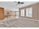 Light-filled living room with neutral carpet, shutters, and open layout with kitchen view at 11730 Stonewall Springs Ave, Las Vegas, NV 89138