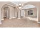 A spacious room with tile floors, arched doorways, and a modern chandelier at 11730 Stonewall Springs Ave, Las Vegas, NV 89138