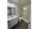 Bright bathroom featuring a single sink vanity, a toilet, and a shower/tub combination with glass doors at 1308 Dusty Creek St, Las Vegas, NV 89128