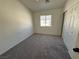Bedroom featuring a window, neutral carpeting and white trim, plus a closet with white sliding doors at 1308 Dusty Creek St, Las Vegas, NV 89128