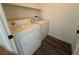 A cozy laundry room featuring a modern washer and dryer with a shelf above at 1308 Dusty Creek St, Las Vegas, NV 89128