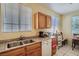Kitchen featuring stainless steel sink, light wood cabinets, granite countertops, and bright lighting at 1375 Gran Vista Ave, Henderson, NV 89012