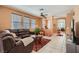 Bright living room featuring tile flooring, natural light, a comfortable sectional sofa, and seamless transition to the dining area at 1375 Gran Vista Ave, Henderson, NV 89012