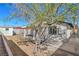 This backyard features a mature shade tree, covered patio, storage shed and block wall at 1945 Margarita Ave, Henderson, NV 89011