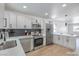 Modern kitchen with stainless steel appliances, white cabinetry, and a dark backsplash at 1945 Margarita Ave, Henderson, NV 89011