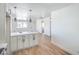 Open-concept living room, connecting to kitchen with a white countertop island and wood-look floors at 1945 Margarita Ave, Henderson, NV 89011