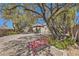 Serene backyard featuring mature trees and a cozy bench amidst well-maintained gravel pathways and lush greenery at 2021 Evansdale St, Henderson, NV 89052