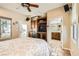 A beautiful bedroom with built-in cabinets, mini-bar, ceiling fan, and an open bathroom with tiled floors at 2021 Evansdale St, Henderson, NV 89052