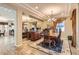 Elegant dining room featuring a chandelier, mirrored wall, and a wooden dining set with ornate chairs at 2021 Evansdale St, Henderson, NV 89052