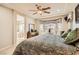 Comfortable main bedroom with a ceiling fan, bay window, and en-suite bathroom with soaking tub at 2021 Evansdale St, Henderson, NV 89052