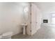 Bathroom with pedestal sink and doorway leading to an airy living room with fireplace at 2124 Brighton Shore St, Las Vegas, NV 89128