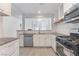 A modern kitchen featuring white cabinets, stainless steel appliances, and gray countertops at 2124 Brighton Shore St, Las Vegas, NV 89128