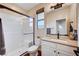 Bright bathroom with glass enclosed shower, light cabinets and modern sink at 2132 Ponticino St, Henderson, NV 89044