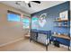 Bedroom with celestial themed blue accent wall with crib and stylish modern furniture at 2132 Ponticino St, Henderson, NV 89044
