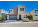 This modern two-story home has a gray garage door, desert landscaping, and a charming arched entryway at 2132 Ponticino St, Henderson, NV 89044