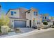 This modern two-story home showcases desert landscaping, a grey garage door, and an arched entryway at 2132 Ponticino St, Henderson, NV 89044