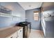 Chic laundry room with blue walls, modern washer and dryer, and convenient shelving at 2132 Ponticino St, Henderson, NV 89044