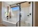 A luxurious bathroom with a sleek glass-enclosed shower and a relaxing soaking tub at 2132 Ponticino St, Henderson, NV 89044