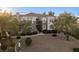 Beautifully landscaped condo exterior with mature trees, stone walkway, and private entrance at 2325 Windmill Pkwy # 1711, Henderson, NV 89074