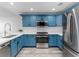 Modern kitchen with blue cabinets, stainless steel appliances, white marble countertops, and light gray wood flooring at 2325 Windmill Pkwy # 1711, Henderson, NV 89074