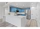 Modern kitchen featuring blue cabinets, stainless steel appliances, a white marble countertop island, and light gray wood flooring at 2325 Windmill Pkwy # 1711, Henderson, NV 89074