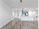 Open-concept living room with gray wood flooring and a view of the kitchen with blue cabinets and a white marble countertop island at 2325 Windmill Pkwy # 1711, Henderson, NV 89074