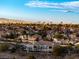 An elevated view of a neighborhood with a sprawling cityscape and mountain range in the distance on a clear, sunny day at 2325 Windmill Pkwy # 1711, Henderson, NV 89074