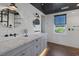 Bright bathroom with a gray double vanity, white subway tile, hardwood floors, and round mirrors at 3069 Lascari Ave, Henderson, NV 89044