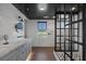 Modern bathroom features a black-framed glass shower, and double vanity with gray cabinets and a marble countertop at 3069 Lascari Ave, Henderson, NV 89044