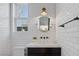 Modern bathroom with a dark vanity, white subway tile, modern light fixture, and bright light from the window at 3069 Lascari Ave, Henderson, NV 89044