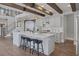 Bright, open kitchen with breakfast bar, white cabinets, stainless appliances, and wood beam ceiling at 3069 Lascari Ave, Henderson, NV 89044