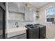 Well-organized laundry room features gray cabinetry, white subway tile, and modern washer and dryer at 3069 Lascari Ave, Henderson, NV 89044